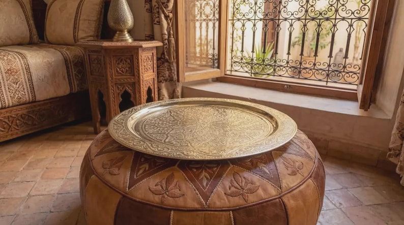 "Top-down view of a golden brass tray with a Moroccan tea set and mint."