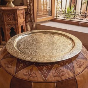 "Large round Moroccan brass tray with intricate hand-engraved geometric patterns."