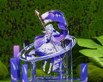 Op de afbeelding: Gedetailleerde acrylfiguur met een personage in een wit en blauw kostuum, met een staf en een vlag met een sterrenontwerp. De figuur staat op een heldere basis met een blauwe en witte decoratieve ring en pilaren. Het thema is fantasie.