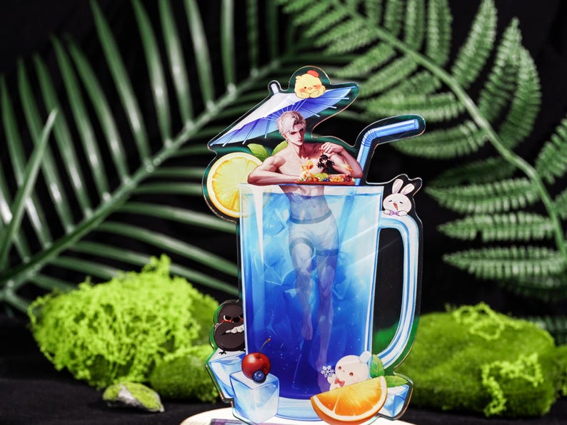 May include: A colorful acrylic drink charm featuring a man in a blue cocktail glass. The charm includes a lemon slice, orange slice, ice cubes, and a straw. Decorative elements include a bunny, a bear, and a penguin.