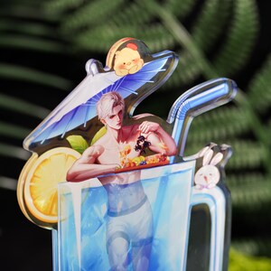 May include: A clear acrylic charm featuring a male anime character in a blue drink. The character is holding a tray of fruit. A lemon slice, a small Winnie the Pooh, and a bunny are also featured.