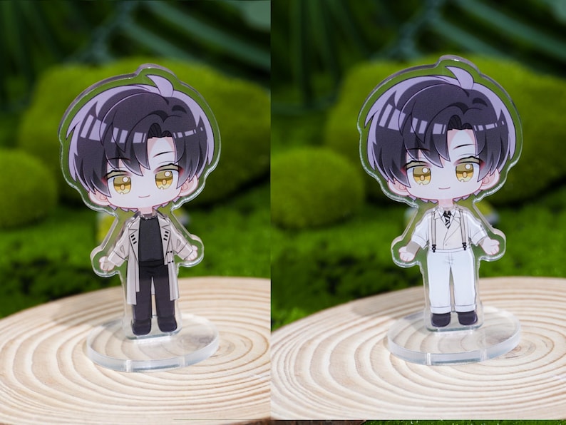 May include: Two acrylic anime-style figurines of a male character with black hair and yellow eyes. One figure wears a black outfit with a tan coat, the other wears a white outfit with suspenders. Both stand on clear bases.