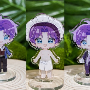 Peut inclure: Trois figurines acryliques de style anime d'un personnage aux cheveux violets et aux yeux bleus. Les figurines sont sur des socles circulaires transparents. Le personnage est repr&eacute;sent&eacute; dans diff&eacute;rentes tenues : un costume, une serviette et une tenue de c&eacute;r&eacute;monie.