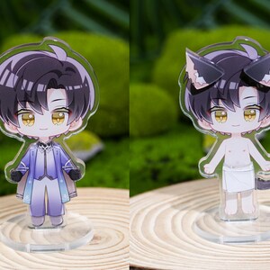May include: Two acrylic anime-style figures. One figure is dressed in a blue and white outfit, the other has cat ears and a tail. Both figures have black hair and yellow eyes. They are standing on clear bases.