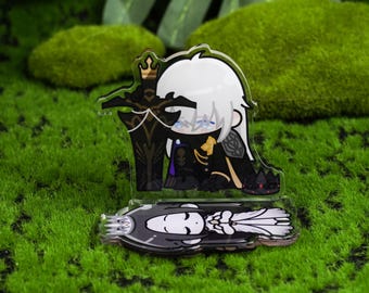 May include: A clear acrylic figure of a crying anime character with white hair, wearing a black and gold outfit, holding a sword. The figure is on a base with a matching design. The background is green.
