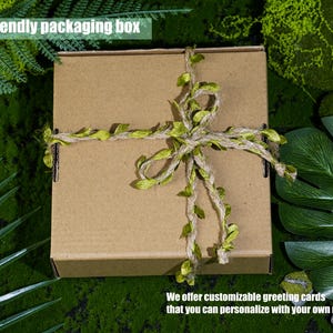 May include: A brown eco-friendly packaging box tied with twine and adorned with green leaf accents. The box is surrounded by green foliage. Text on the image reads: "Eco-friendly packaging box" and "We offer customizable greeting cards that you can personalize with your own message."
