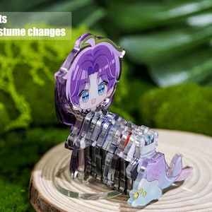 Peut inclure: Une figurine transparente en acrylique repr&eacute;sentant un personnage d'anime aux cheveux violets et aux yeux bleus. La figurine est assembl&eacute;e &agrave; partir de plusieurs pi&egrave;ces et pr&eacute;sente un design fantaisiste. Le texte de l'image indique "12 sets of costume changes".