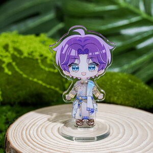 Peut inclure: Figurine transparente de style anime repr&eacute;sentant un personnage aux cheveux violets et aux yeux bleus, v&ecirc;tu d'une tenue blanche et bleue. La figurine est pos&eacute;e sur une base transparente, sur fond de feuillage vert et de rondin de bois.