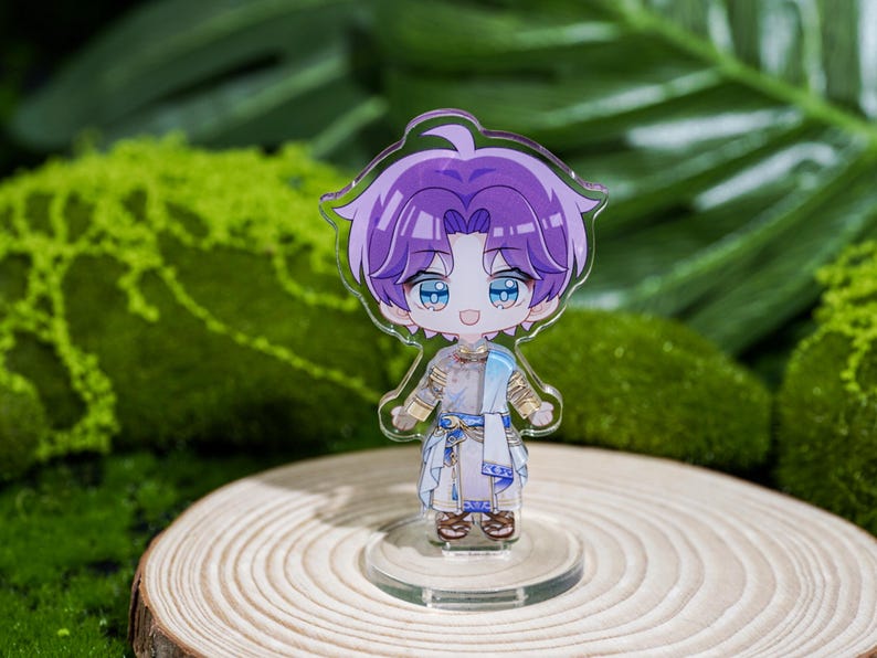 Peut inclure: Figurine transparente de style anime repr&eacute;sentant un personnage aux cheveux violets et aux yeux bleus, v&ecirc;tu d'une tenue blanche et bleue. La figurine est pos&eacute;e sur une base transparente, sur fond de feuillage vert et de rondin de bois.