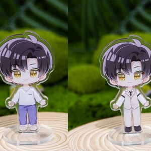 May include: Two acrylic anime-style figures of a male character with black hair and yellow eyes. One figure wears a white shirt and purple pants, the other wears a white suit. Both figures stand on clear circular bases.