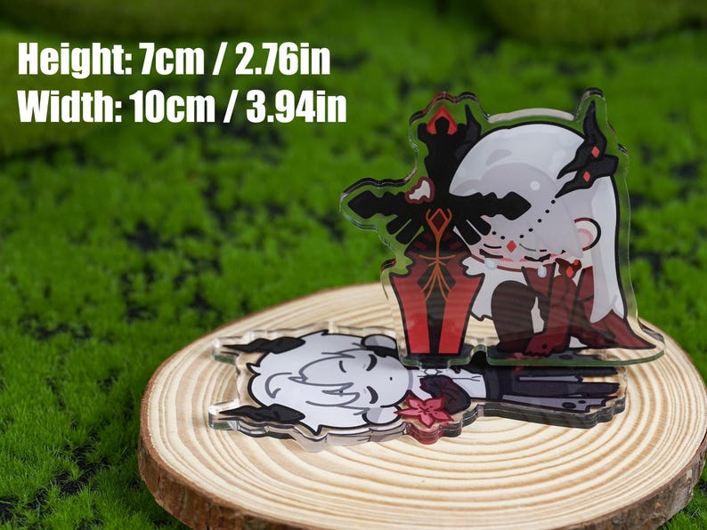 K&ouml;nnte beinhalten: Zwei Acryl-Anh&auml;nger mit Anime-Charakteren, einer stehend und einer liegend. Der stehende Anh&auml;nger hat ein schwarzes Schwert und rote Akzente. Die Anh&auml;nger sind 7 cm hoch und 10 cm breit. Sie liegen auf einer Holzscheibe.