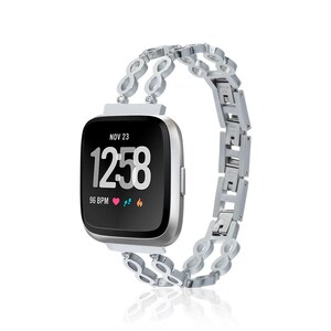 May include: A silver smartwatch with a black screen displaying the time as 12:58, date as Nov 23, and a heart rate of 96 BPM. The watch has a silver band with an infinity loop design.