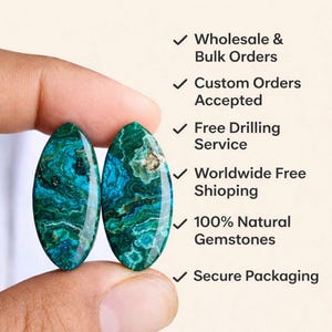 May include: Two oval-shaped, natural gemstones with a teal and green marbled pattern are held between fingers. The image includes text: MPGEMSINDIA, Natural Gemstone, Wholesale & Bulk Orders, Custom Orders Accepted, Free Drilling Service, 100% Natural Gemstones.