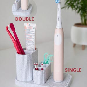 Può includere: Un set di tre tazze in ceramica con smalto screziato color crema. Ogni tazza presenta un diverso motivo floreale dipinto a mano nei toni del blu, verde e giallo. Le tazze hanno una forma semplice e arrotondata e un manico.