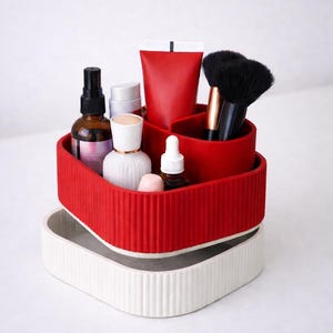 Puede incluir: Un organizador rojo y blanco de dos niveles lleno de productos de belleza. El nivel superior es rojo y contiene brochas de maquillaje, un tubo rojo y varias botellas. El nivel inferior es blanco. El organizador est&aacute; dise&ntilde;ado para guardar cosm&eacute;ticos y productos para el cuidado de la piel.