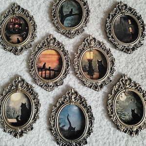 Könnte beinhalten: Eine Sammlung von acht Miniatur-Gemälden in antiken Rahmen. Jedes Gemälde zeigt eine schwarze Katze in einer anderen Nachtszene, darunter ein Haus, ein Baum, ein Pier und unter einer Straßenlaterne. Die Rahmen haben eine verzierte, metallische Oberfläche.