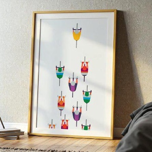 Könnte beinhalten: Ein gerahmter Kunstdruck mit einer minimalistischen Illustration von Fahrrädern in verschiedenen Farben. Das Kunstwerk zeigt Fahrräder in Gelb, Grün, Rot und Lila vor einem weißen Hintergrund. Der Rahmen hat einen warmen, natürlichen Holzton.