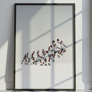 Può includere: Una stampa artistica incorniciata con una sequenza d'azione di basket in bianco e nero. L'opera raffigura giocatori in movimento, su sfondo bianco, con una cornice nera. La stampa è appoggiata a una parete bianca in una stanza con pavimento piastrellato.