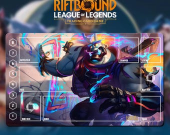 May include: A Riftbound League of Legends trading card game playmat. The mat features a large illustration of a character with blue and purple tones. The mat has zones for cards, including a rune deck, runes, and a main deck. Text at the top reads "Riftbound League of Legends Trading Card Game."