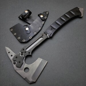 Pu&ograve; includere: Un tomahawk tattico con manico nero e lama grigia. L'ascia &egrave; dotata di un fodero in pelle con passante per cintura. Il design include una punta sul retro della testa e un foro vicino alla lama.
