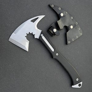 May include: A silver and black hatchet with a curved blade and a black handle. The hatchet has a protective black leather sheath with silver rivets. The hatchet is designed for outdoor use.