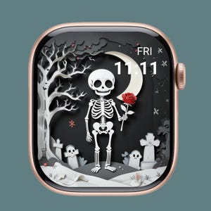 Op de afbeelding: Een roségouden Apple Watch toont een Halloween-thema wijzerplaat. Het ontwerp toont een wit skelet met een rode roos, een halve maan en een kerkhofscène met grafstenen en een boom. De tijd is 11:11.