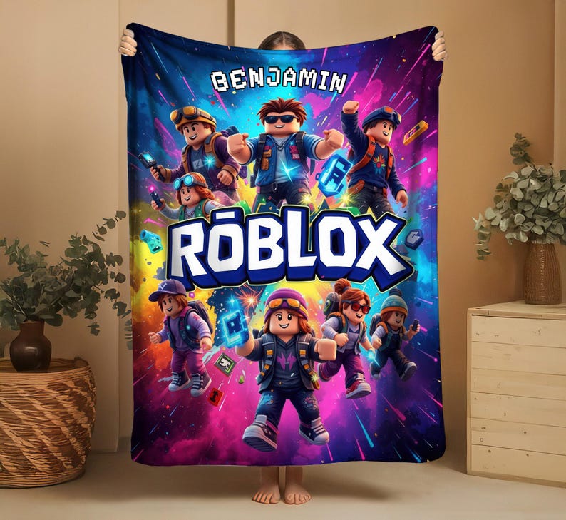 May include: A vibrant, colorful blanket featuring a Roblox theme. The blanket displays multiple Roblox characters in action poses against a dynamic, space-themed background. The name "BENJAMIN" is printed at the top, and the Roblox logo is prominently displayed.