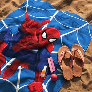 May include: A blue beach towel featuring a red and blue Spider-Man graphic with a white web pattern, accompanied by a pair of tan flip-flops, a small bottle of orange nail polish, two pink nail files, and a small round red object.