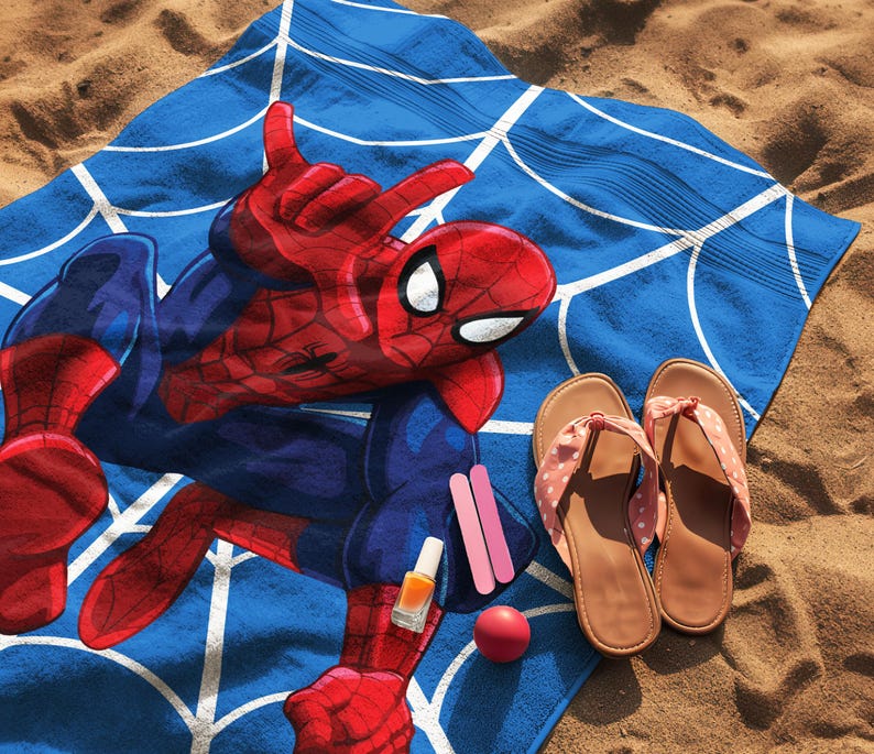 May include: A blue beach towel featuring a red and blue Spider-Man graphic with a white web pattern, accompanied by a pair of tan flip-flops, a small bottle of orange nail polish, two pink nail files, and a small round red object.