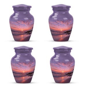 May include: Four purple urns with a sunset scene featuring a heart-shaped formation of birds. The urns have a rounded body and a matching lid. The sunset scene includes a beach, ocean, and colorful sky.