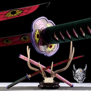 May include: A collection of decorative Japanese swords with red and black blades, featuring eye-shaped designs. The swords are displayed with a deer antler stand and a silver demon mask, set against a dark background.