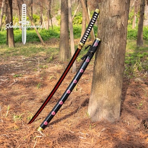 Könnte beinhalten: Ein schwarzes Katana mit roter Klinge und einer schwarzen Scheide, die mit rosa geometrischen Formen verziert ist. Das Katana lehnt an einem Baum in einer Waldumgebung. Der Text "Shadowkatanaone" befindet sich in der oberen linken Ecke.