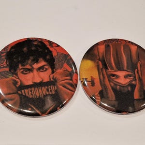 May include: Two circular badges with red and black illustrations. One shows a person with the text "KENONOCED" across their mouth. The other depicts a person with their hands covering their ears.