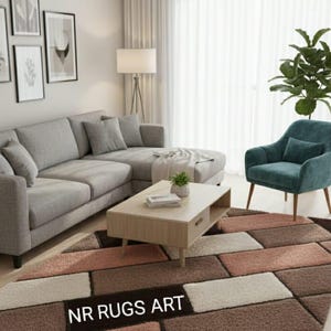 Op de afbeelding: Een woonkamer met een geometrisch patroon tapijt in bruin, beige en roze tinten. Een lichte houten salontafel en een grijze hoekbank zijn aanwezig. De tekst "NR RUGS ART" is zichtbaar op het tapijt.