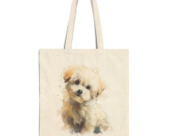 May include: Cream-colored tote bag featuring a watercolor painting of a fluffy, light-brown puppy. The puppy has dark eyes and is sitting. The bag has long handles for carrying over the shoulder. The design is printed on a natural-colored canvas.