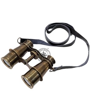 K&ouml;nnte beinhalten: Antikes Messingfernglas mit schwarzem Lederriemen. Das Fernglas hat ein klassisches Design mit einem Fokus-Einstellrad und eignet sich f&uuml;r nautische oder Vintage-Dekorationen.