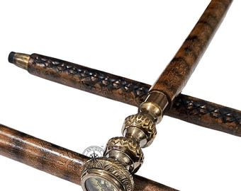 Könnte beinhalten: Vintage-Spazierstock mit einem Kompass im Griff. Der Stock hat einen braunen, lederummantelten Schaft mit dekorativen Nähten und Messingakzenten. Der Kompass ist in einem Messinggehäuse untergebracht und vereint Funktionalität mit Dekor.