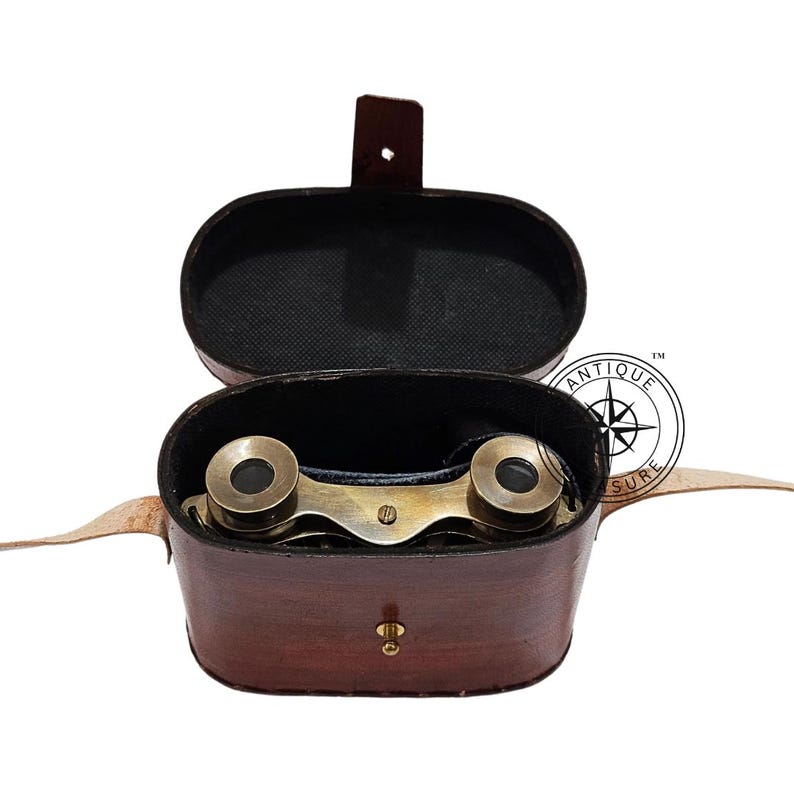 K&ouml;nnte beinhalten: Antike Operngl&auml;ser aus Messing in einem braunen Lederetui. Das Etui ist ge&ouml;ffnet und zeigt die Messinggl&auml;ser mit schwarzen Linsen. Das Etui hat einen Lederriemen und einen Schnallenverschluss. Ein Vintage-Artikel.