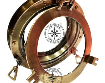 Könnte beinhalten: Satz von drei antiken Messing-Bullaugen mit klarem Glas. Die Bullaugen haben ein kreisförmiges Design und einen Klappmechanismus. Der Text "ANTIQUE TREASURE" ist auf dem Glas aufgedruckt. Mit nautischem Thema.