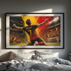 Könnte beinhalten: Ein gerahmter Kunstdruck, der einen Fußballspieler in einem schwarz-roten Trikot mit der Nummer 7 und dem Wort BELGIUM auf dem Rücken zeigt, der mit erhobenen Armen auf einem Spielfeld vor einer Zuschauermenge in Gelb und Rot kniet.