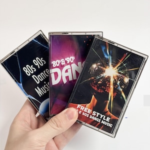 May include: Three vintage cassette tapes with colorful covers. One tape reads "80s 90s Dance Music", another says "80's & 90's DAN", and the third features a disco ball and the text "FREE STYLE & 90S DANCE MUSIC".