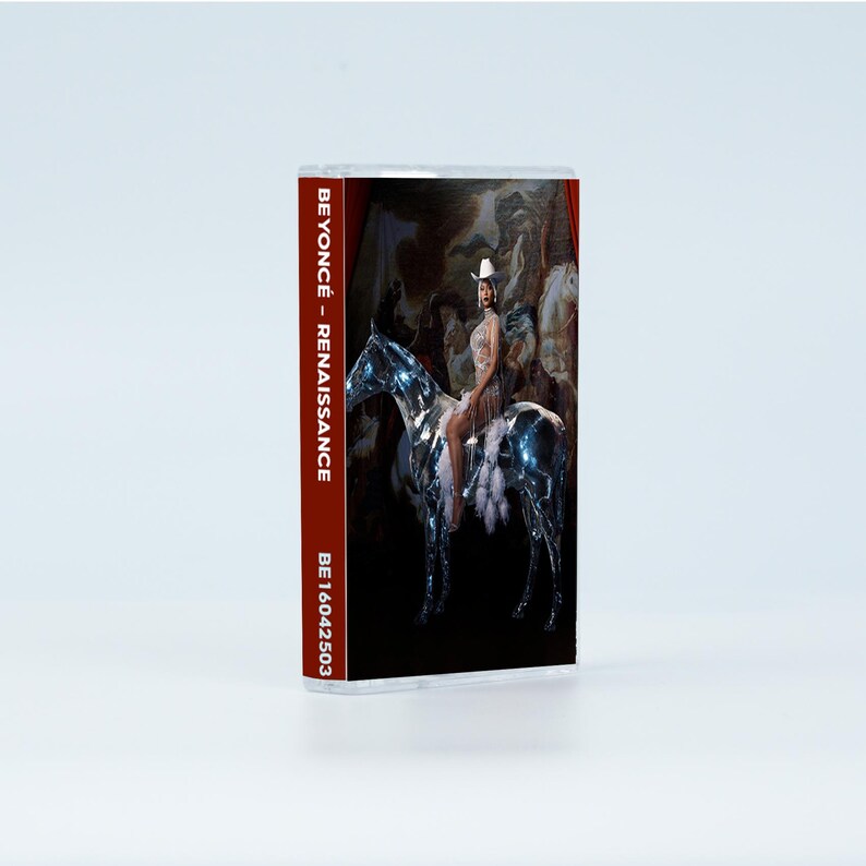 May include: A cassette tape case featuring the Renaissance album cover art. The spine displays the text BEYONC&Eacute; - RENAISSANCE and BE16042503. The cover image depicts a person in a white cowboy hat riding a metallic, reflective horse against a dark background.