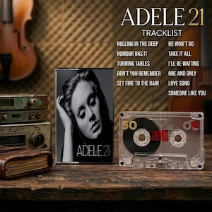 May include: A black and white Adele 21 album cover featuring a portrait of the artist, alongside a clear plastic cassette tape with the number 50 and the word ZAPAR printed on it. The tracklist includes Rolling in the Deep and Someone Like You.