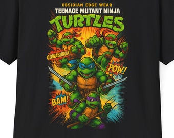 May include: Black t-shirt with a Teenage Mutant Ninja Turtles graphic. The design includes the words "Cowabunga," "Pow," and "Bam!" in a comic book style. The shirt is made of a soft material.