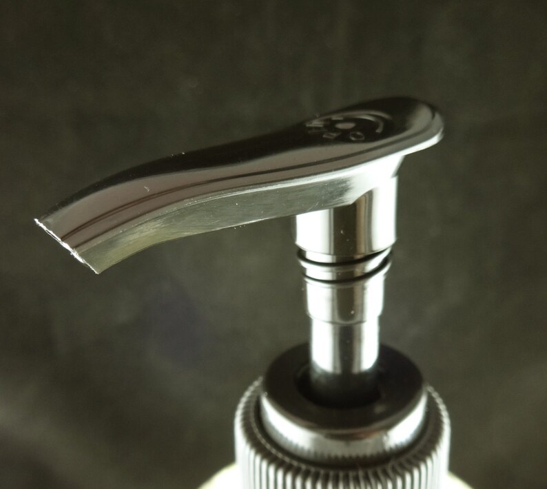May include: A black pump bottle with a silver top and a curved spout. The pump is made of metal and has a shiny finish.