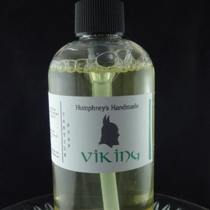 May include: A clear bottle of liquid soap with a black pump top. The label reads "Humphrey's Handmade Castile Soap Viking".