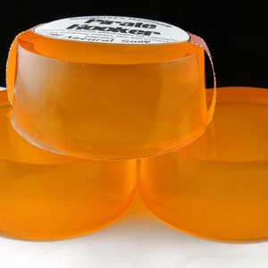 Pu&ograve; includere: Tre saponette artigianali di colore arancione impilate l'una sull'altra. La saponetta in cima ha un'etichetta che recita "Humphrey's Handmade Pale Hooker Soap - Natural".