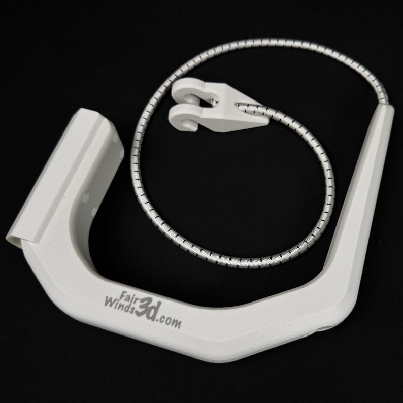 Pode incluir: Uma al&ccedil;a de pl&aacute;stico branca em forma de U com o texto FairWinds3d.com impresso na lateral. Preso &agrave; al&ccedil;a est&aacute; um cord&atilde;o el&aacute;stico tran&ccedil;ado prateado e branco que se conecta a um pequeno gancho de pl&aacute;stico branco de duas pontas.
