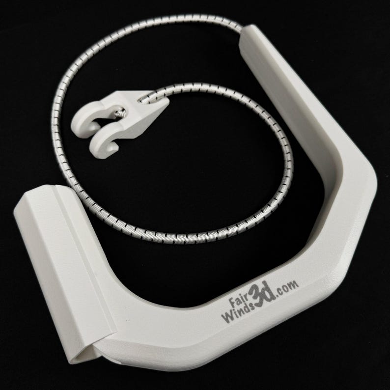 Pode incluir: Um punho de pl&aacute;stico branco com formato curvo e angular, com o texto FairWinds3d.com impresso na lateral. Um cord&atilde;o el&aacute;stico fino, prateado e branco, est&aacute; preso ao punho, apresentando um pequeno gancho de pl&aacute;stico branco na ponta.