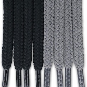 May include: A set of eight flat shoelaces arranged vertically, featuring four solid black laces and four solid gray laces. Each lace has a braided texture and is finished with a smooth, matching plastic aglet at the bottom end for durability.